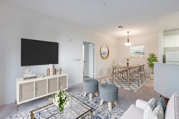 a living room and dining room with a table and a television